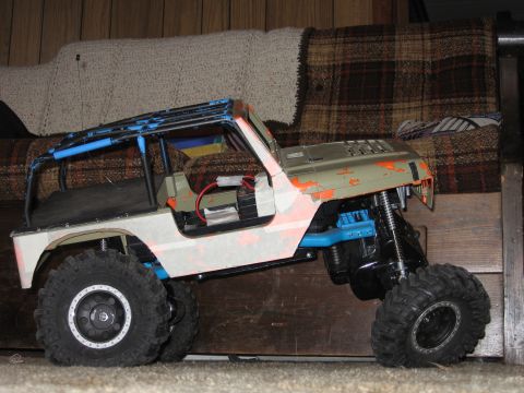 1984 Ford Bronco - This remote control rock crawler toy has a modified body with an exposed interior and a blue roll cage.