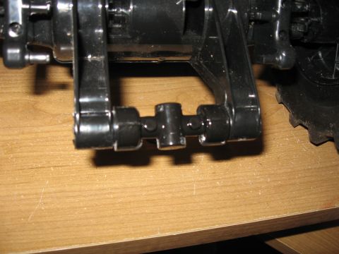 1990 Ford Bronco - Close-up view of black plastic suspension components and a portion of a tire on a wooden surface.