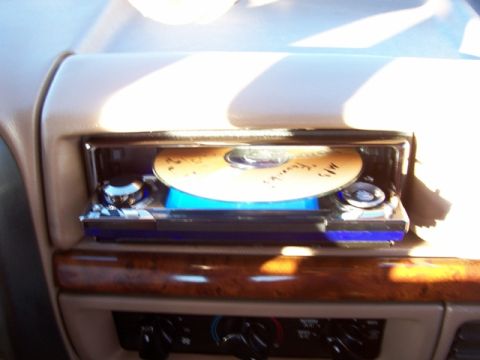 1996 Ford Bronco - The interior of a vehicle shows a CD player with a disc inserted, along with dashboard controls.
