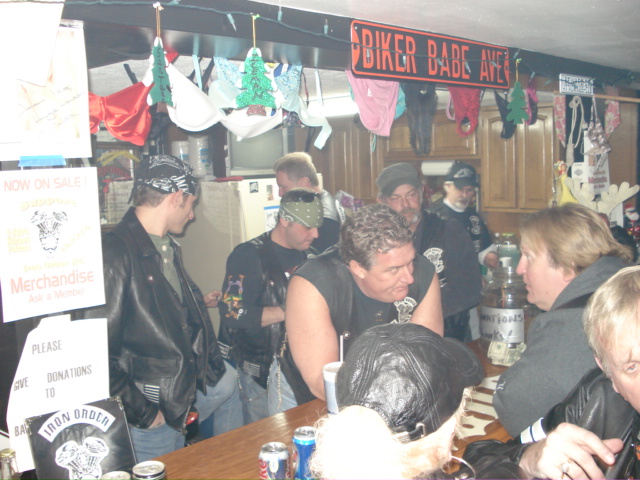 People gathered at a bar with bras and panties hanging above