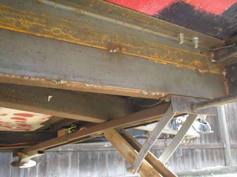 1990 Ford Bronco - Close-up view of a trailer's structural frame and a deployed scissor jack.