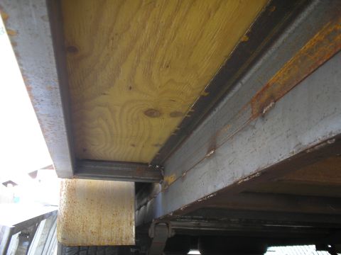 1990 Ford Bronco - Close-up view of the underside of a trailer, highlighting its wooden deck and metal support structure.