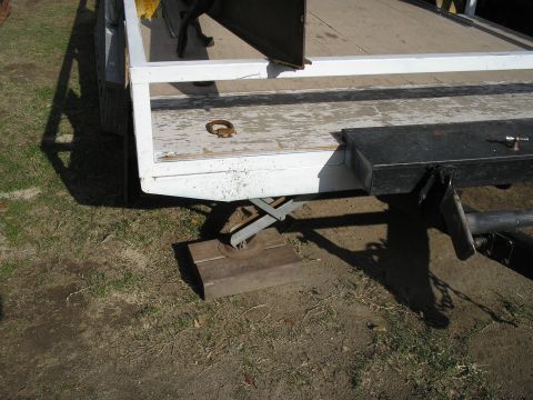 1990 Ford Bronco - Close-up view of a trailer bed, showing a jack stand and a tie-down ring. The registry information for a 1990 Ford Bronco is incorrect.