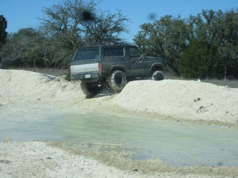 1986 Ford Bronco - This Ford Bronco is navigating an off-road course with a water hazard.