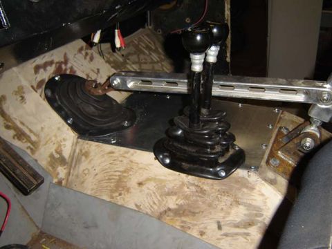1971 Ford Bronco - Close-up of a vehicle's interior, focusing on the dual shifter assembly and surrounding floor components.