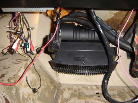 1971 Ford Bronco - Close-up of vehicle's under-dash wiring and audio equipment, including an amplifier and RCA connectors. The SuperMotors logo is visible at…