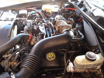 1992 Ford Crown Victoria - Close-up view of a car's engine bay, showing various components and hoses.