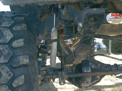2005 Ford Excursion - Detail shot of a vehicle's suspension system, a large tire and a Holley Street Avenger sticker.