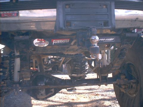 2005 Ford Excursion - The underside of a modified truck shows its suspension components and trailer hitch, with aftermarket parts branded on the frame.