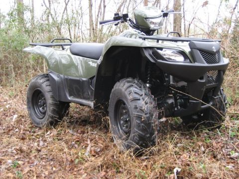 2004 Ford F-150 - A green Suzuki King Quad 4x4 ATV is parked in a wooded area with dry leaves on the ground.