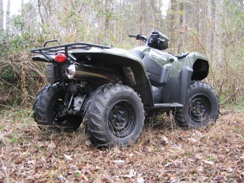2004 Ford F-150 - ATV parked in a wooded area, showing its rear end and large tires.