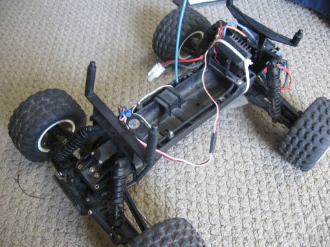 1974 Ford F-100 - The internal components and chassis of a remote control car are visible, showing the suspension and wiring.