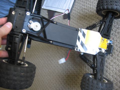 1974 Ford F-100 - The underside of a remote control car chassis is shown, with its suspension and electronic components.