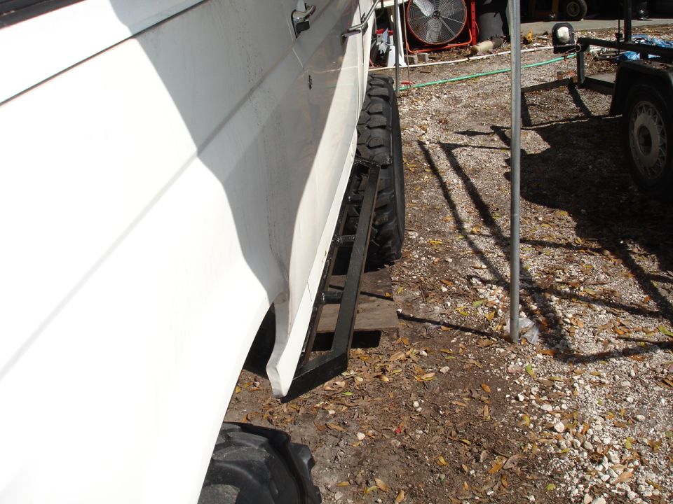 White SUV side with aftermarket running boards and large tires