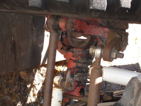 1989 Ford Bronco - This image shows a close-up view of worn and rusty vehicle suspension components, including linkages and bolts.