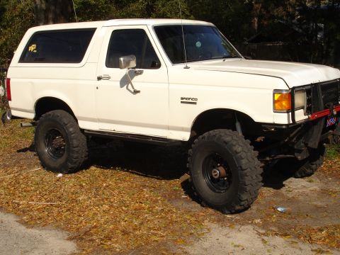 1989 Ford Bronco - This white Ford Bronco SUV has a lifted suspension and large off-road tires.