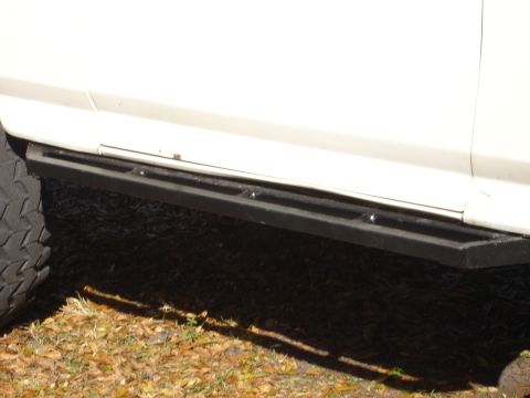 1989 Ford Bronco - Side view of a slider bar and tire on a white vehicle.