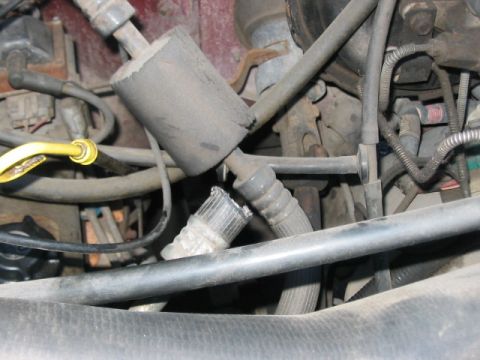 1991 Ford Bronco - Close-up view of a damaged hose and insulation within a vehicle's engine bay.
