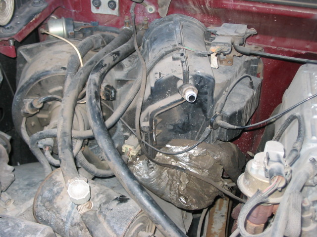 Engine bay with heater core assembly, hoses, and wiring