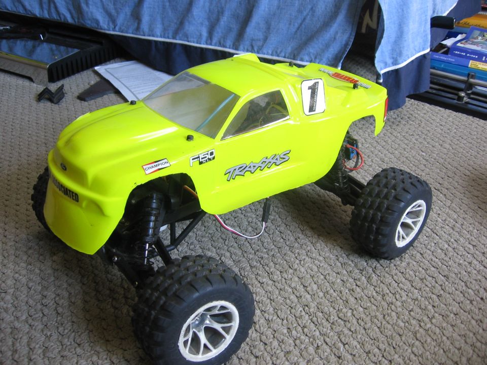 Yellow remote control truck with "F150" and "Traxxas" decals