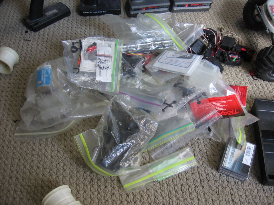 Pile of RC car parts in plastic bags on carpet