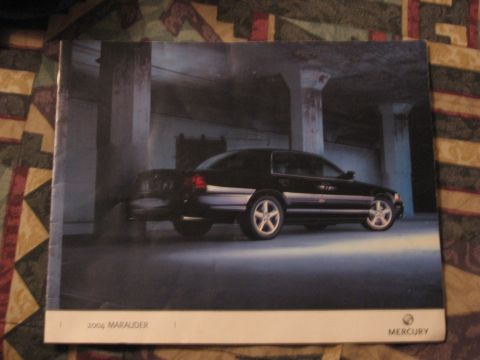 1988 Mercury Grand Marquis - This image shows a black sedan with silver trim, likely a 2004 Marauder, in a three-quarter front view.