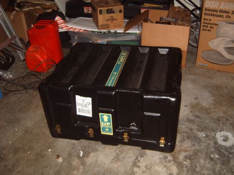 1988 Ford Bronco - A large black storage case is the main focus, surrounded by clutter in what appears to be a garage or storage area.