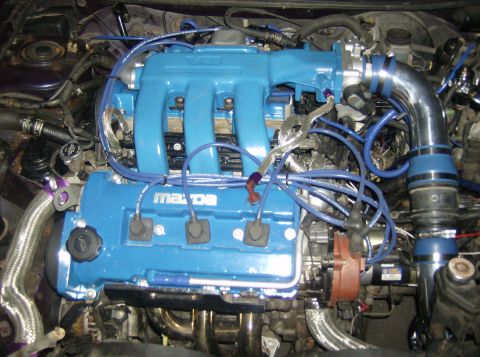 1996 Ford Probe - Close-up of a modified engine bay a blue painted Mazda engine with custom intake piping.