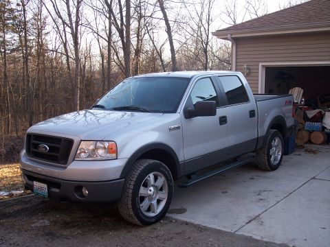 2007 Dodge Durango - Silver Ford F-150 pickup truck with dark gray trim parked in front of a garage.