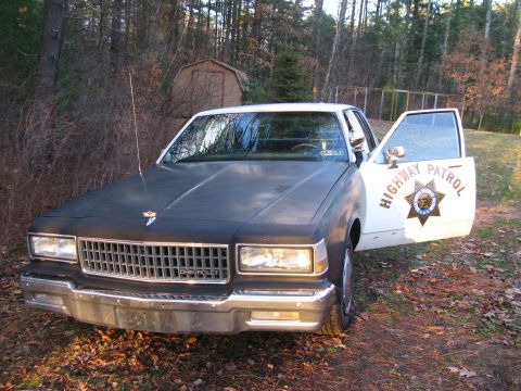 1991 Ford LTD Crown Victoria - This Chevrolet Caprice police car has a "HIGHWAY PATROL" badge on the open driver's door.