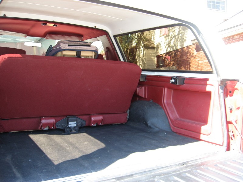 Interior cargo area of a vehicle with red seats and black carpet