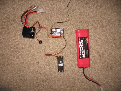 1990 Ford Bronco - Various electronic components for an RC car, including an ESC, receiver, servo, and a Dyna-Fun 2000 battery pack.