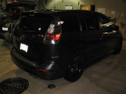 2006 Mazda Mazda 5 - Rear view of a black 2006 Mazda Mazda 5 in a workshop setting.