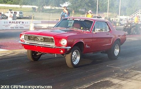 1963 Ford Fairlane - A red 1967 Ford Mustang is shown on a drag strip with smoke in the background.