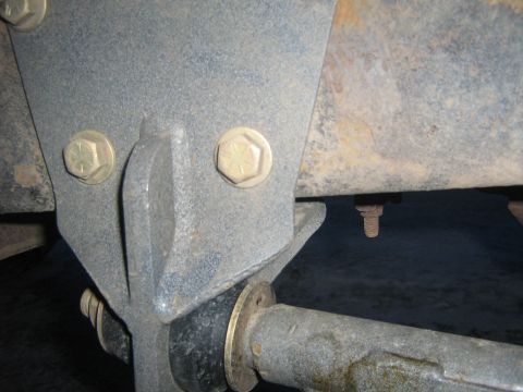1995 Ford Bronco - Undercarriage view of a vehicle's suspension component, showing metal brackets and bolts.