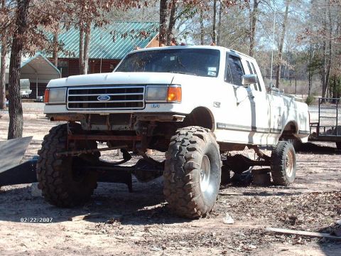 1990 Ford F-150 - This modified 1990 Ford F-150 pickup features a significant suspension lift and massive off-road tires.