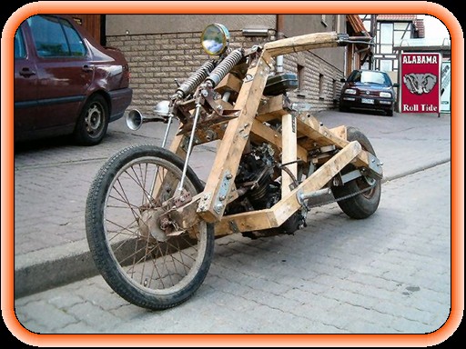 Homebuilt wooden-frame chopper motorcycle with spoked front wheel parked on sidewalk