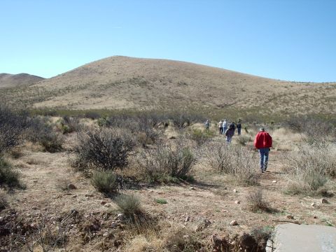 1996 Ford Bronco - Hikers traverse a dry, arid terrain under a clear blue sky.