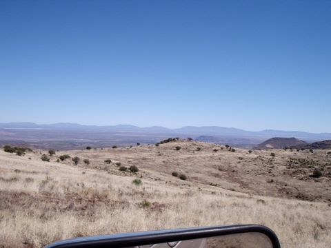 1996 Ford Bronco - A wide view of a dry, hilly landscape under a clear blue sky, seen from a vehicle.