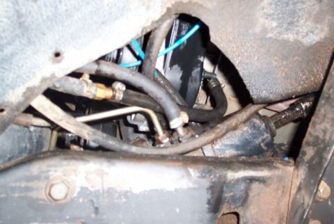 1986 Ford Bronco - Van high pressure line enters steering box (steel line at right angle). Also visible: return line entering rear of pump reservoir.
