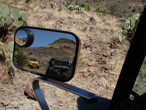 1996 Ford Bronco - Two Jeeps navigate a , dry, mountainous terrain, seen from the perspective of one of the vehicles.