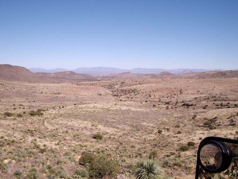 Desert landscape with a side mirror in the foreground