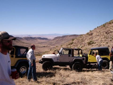 1996 Ford Bronco - Several off-road vehicles are gathered in a scenic, arid landscape under a clear blue sky.