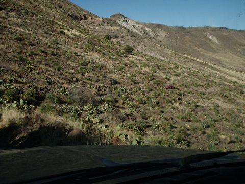 1996 Ford Bronco - Two vehicles are visible on a sparsely vegetated hillside under a bright blue sky.