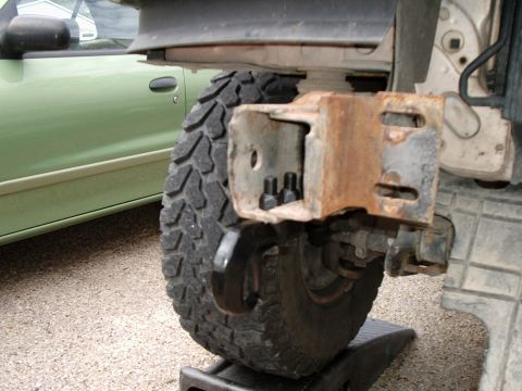 1996 Ford Bronco - Close-up view of a tow hook mount and bolts, indicating installation or repair work on a vehicle's front end.