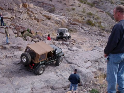 1996 Ford Bronco - Off-road vehicles navigate a challenging rocky terrain under a clear sky.