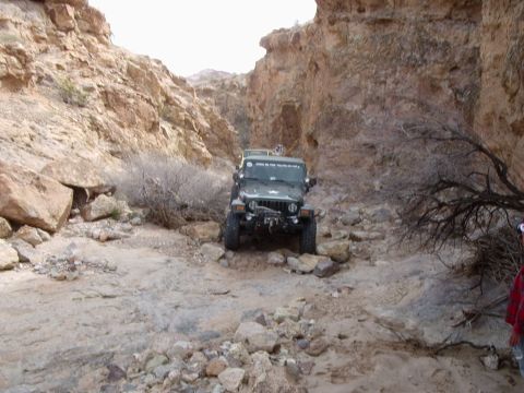 1996 Ford Bronco - Two Jeeps navigate a narrow, rocky canyon trail.
