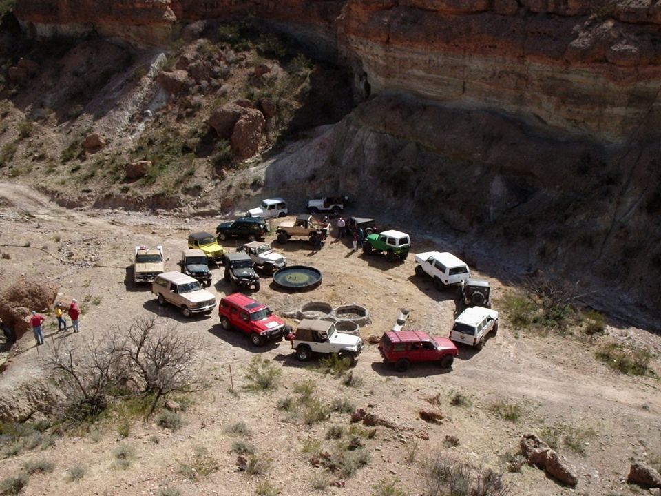 Group of off-road vehicles parked in a circle in a desert canyon