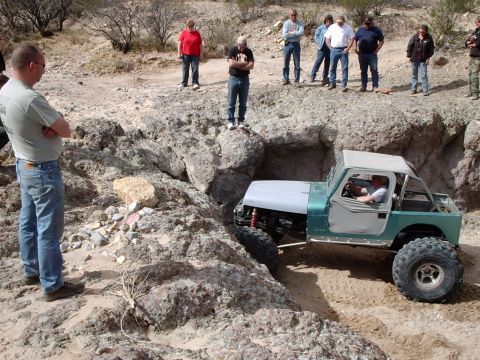 1996 Ford Bronco - Spectators watch as an off-road vehicle tackles a challenging rocky terrain.