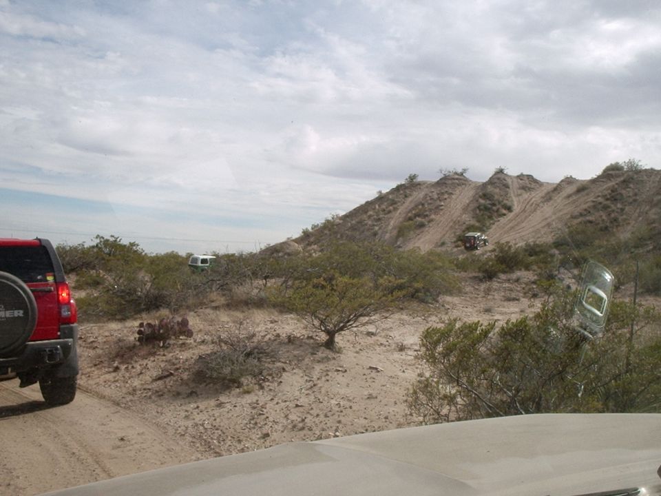 Red SUV and white camper van on a desert trail